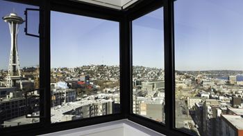 A view of a city from a window with a Seattle Space Needle in the background at Skye at Belltown Apartments, Seattle, 98121